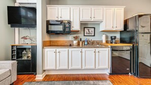 A kitchen with white cabinets, a black refrigerator, a microwave, and a coffee maker. - Steps to Smith Mountain Lake: Unit w/ Pool Access! (Huddleston)