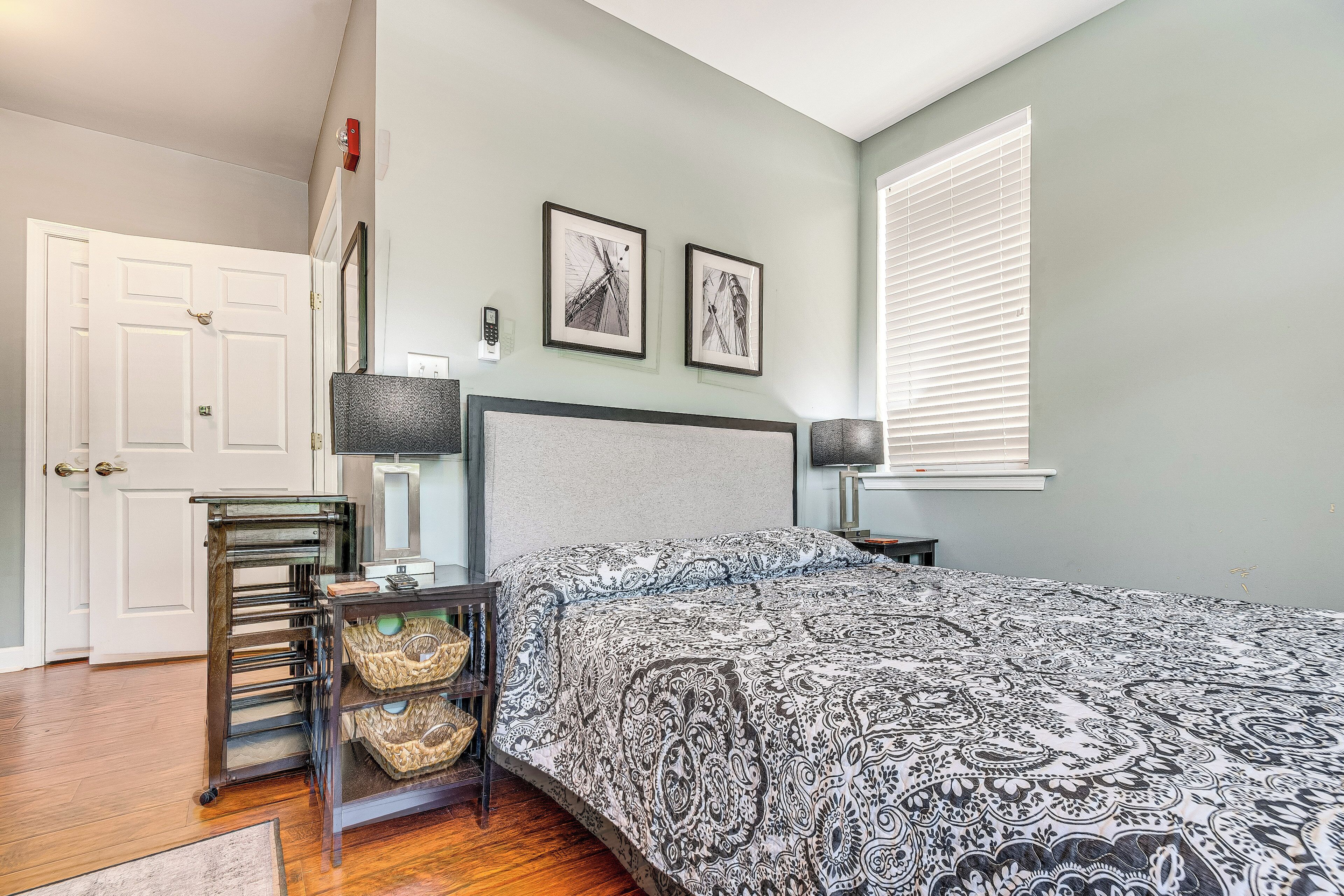 Une chambre à coucher avec un lit, une table de chevet, une lampe, une chaise et une porte.