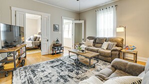 A living room with a sofa, coffee table, TV, and a ceiling fan. - Dog-friendly Home w/ Yard, 6 Mi to Louisville! (New Albany)