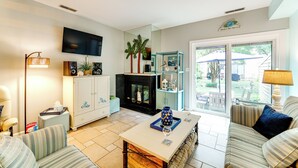 A living room with a fireplace, a television, and a dining area with a table and chairs. - ~ 1 Block to Bethany Beach, Retreat w/ Pool Access (Bethany Beach)