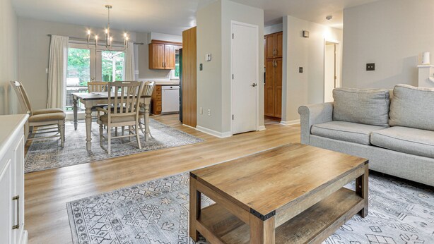 A spacious living room with a wooden coffee table, a grey sofa, and a dining area with chairs and a table. - Patio, 2 Living Rooms, 5 Mi to Beaver Stadium (State College)