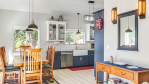 A modern kitchen with white cabinets, a wooden dining table, and a red rug. - Lake Lover's Paradise: Waterfront Home in Hayden! (Hayden)
