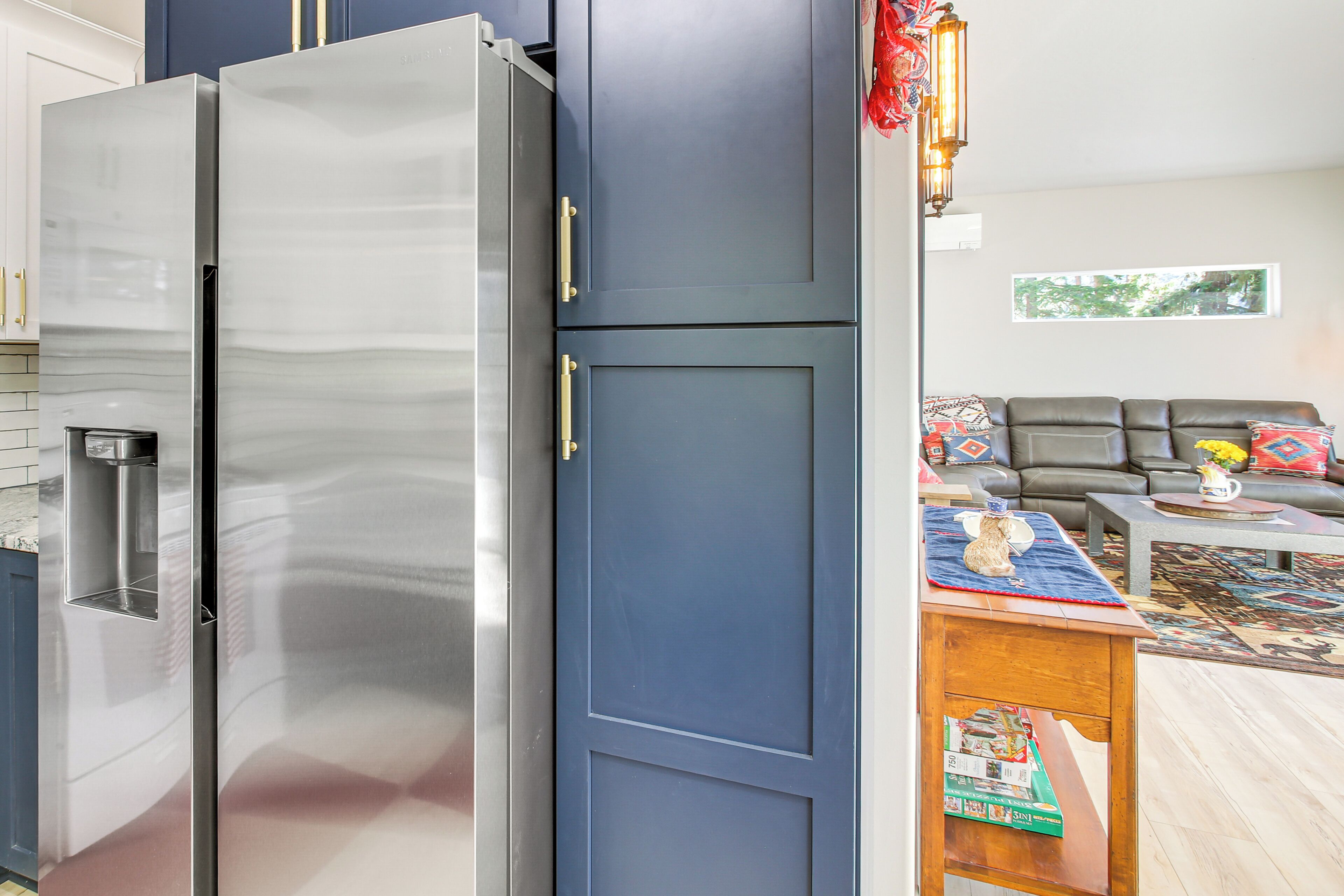 Een moderne keuken met een roestvrijstalen koelkast, een blauwe kast en een waterdispenser.