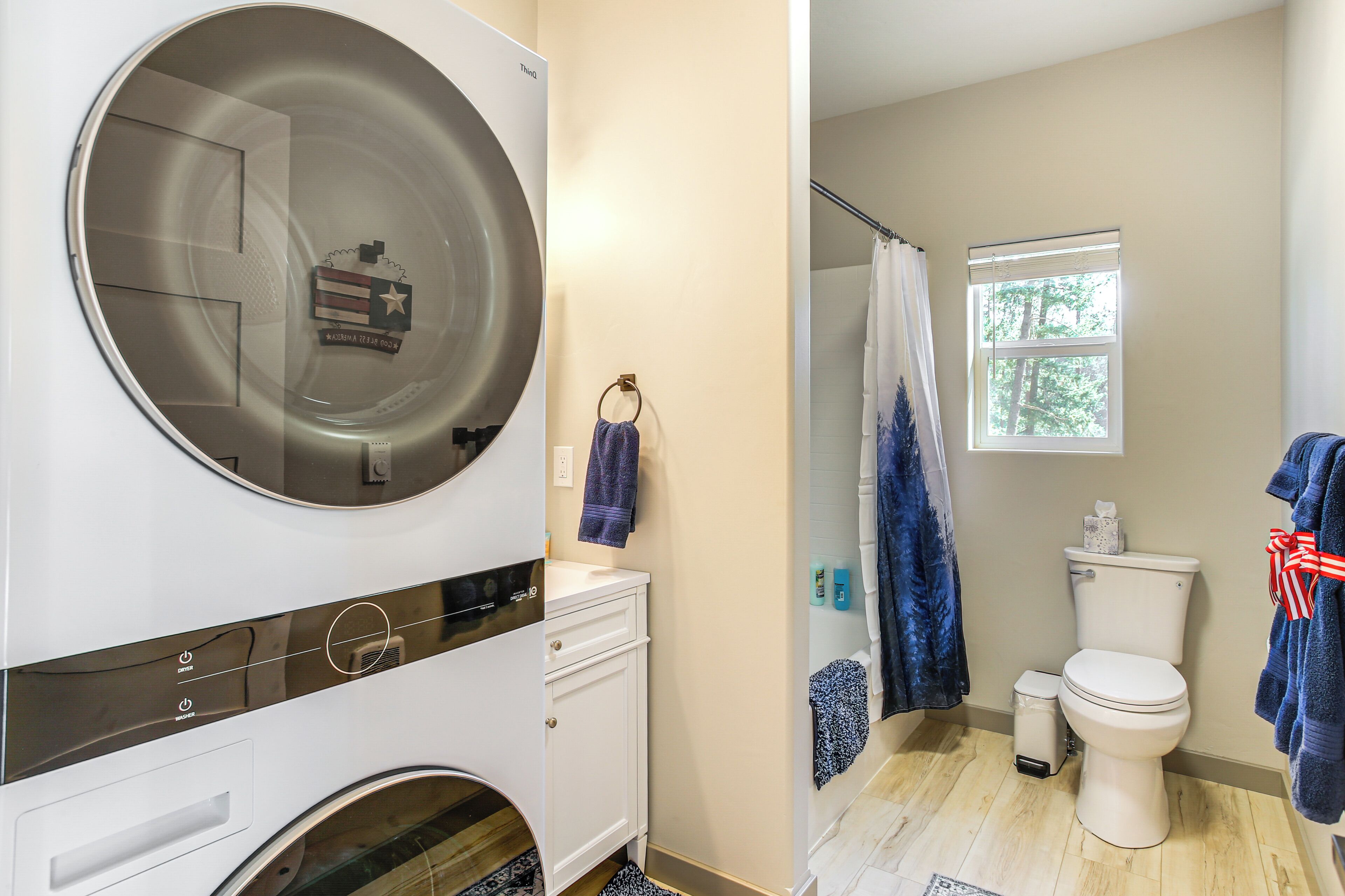 A compact bathroom with a built-in washer and dryer, a toilet, and a shower area.