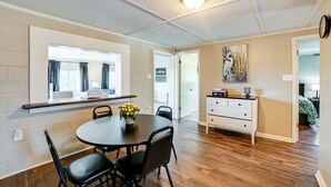 A dining area with a round table, black chairs, a potted plant, and a white cabinet with drawers. - Private Dock & Slip: Kentucky Lake Cottage! (Buchanan)