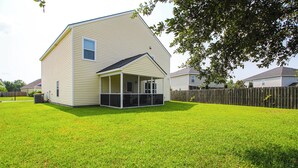 A two-story house with a covered patio and a fenced yard. - Spacious Home w/ Screened Patio in Pooler! (Pooler)