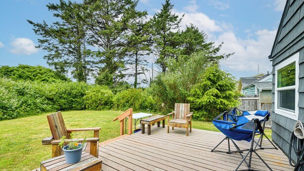 Una terraza de madera con mobiliario exterior, incluyendo sillas, una mesa y una silla de jardín azul.