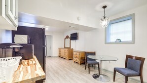 A modern kitchen with a wooden countertop, a refrigerator, a dining table with chairs, and a chandelier. - Easy Highway Access: Low-key Norcross Studio! (Norcross)