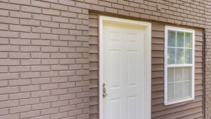 A brick exterior with a white door and a window with blinds. - Easy Highway Access: Low-key Norcross Studio! (Norcross)