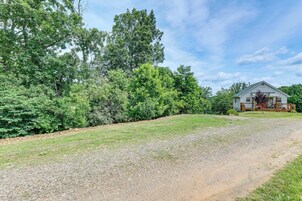 A house with a gravel driveway and a grassy lawn.