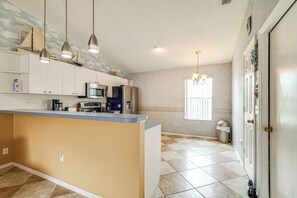 A kitchen with a central island, overhead pendant lights, and a built-in microwave. - 2BR Pet-friendly Vacation Rental The Villages! (Lady Lake)