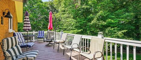 A wooden deck with outdoor furniture, including striped sofas and chairs, and a table.