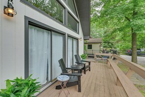 A deck with outdoor seating and a small table, overlooking a residential area with a house and trees. - Pool & Marina Access: Lewes Home w/ Fenced Yard! (Lewes)