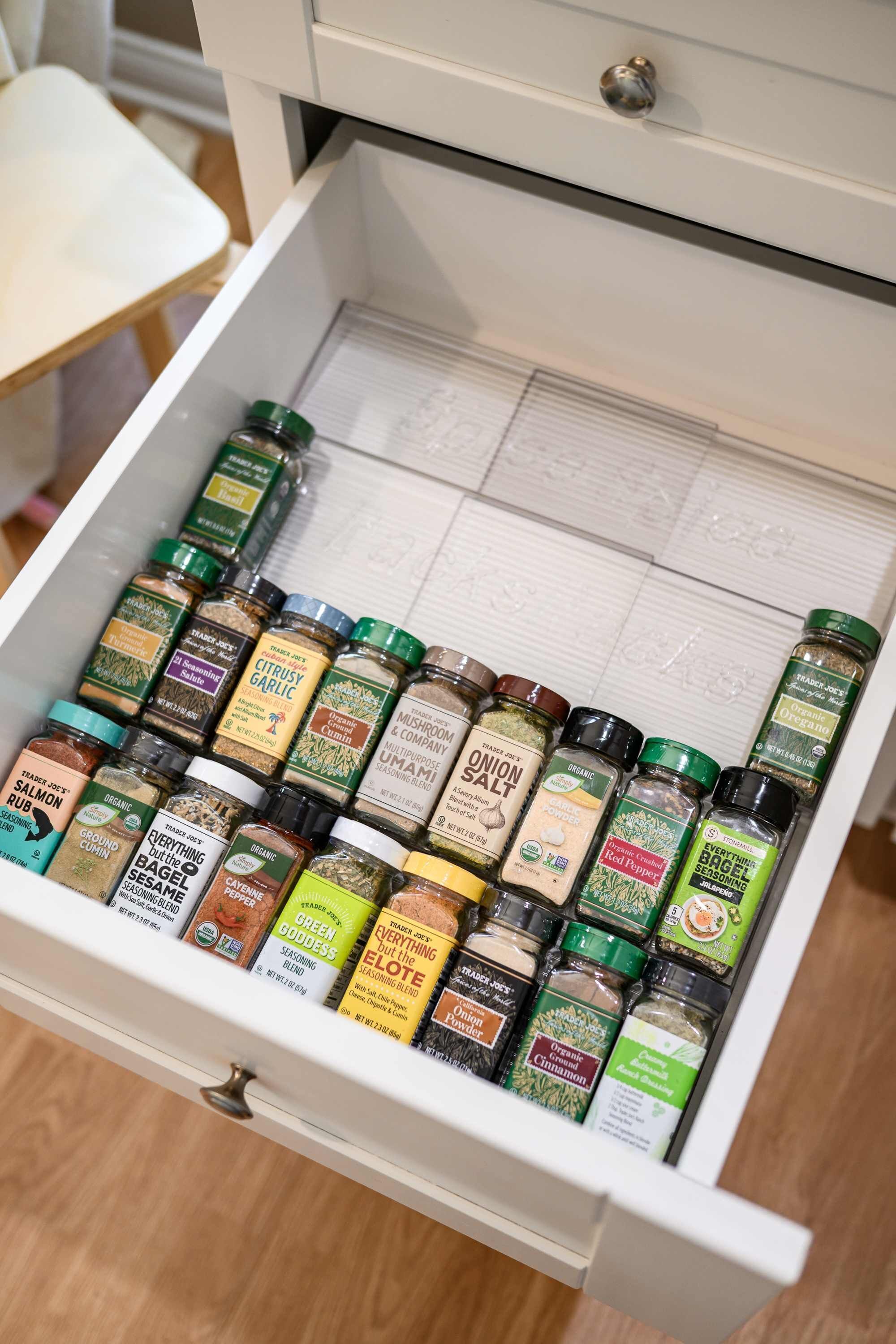 A drawer filled with various spice jars.