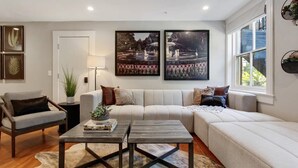 A living room with a sofa, armchairs, a coffee table, and artwork on the wall. - Cozy 1BR Historic Condo | Downtown Savannah (Savannah)