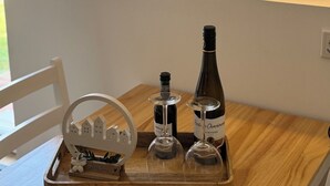 A wooden tray with a wine bottle, two wine glasses, and a decorative item on a table. - Cozy vacation apartment in the heath (Hodenhagen)