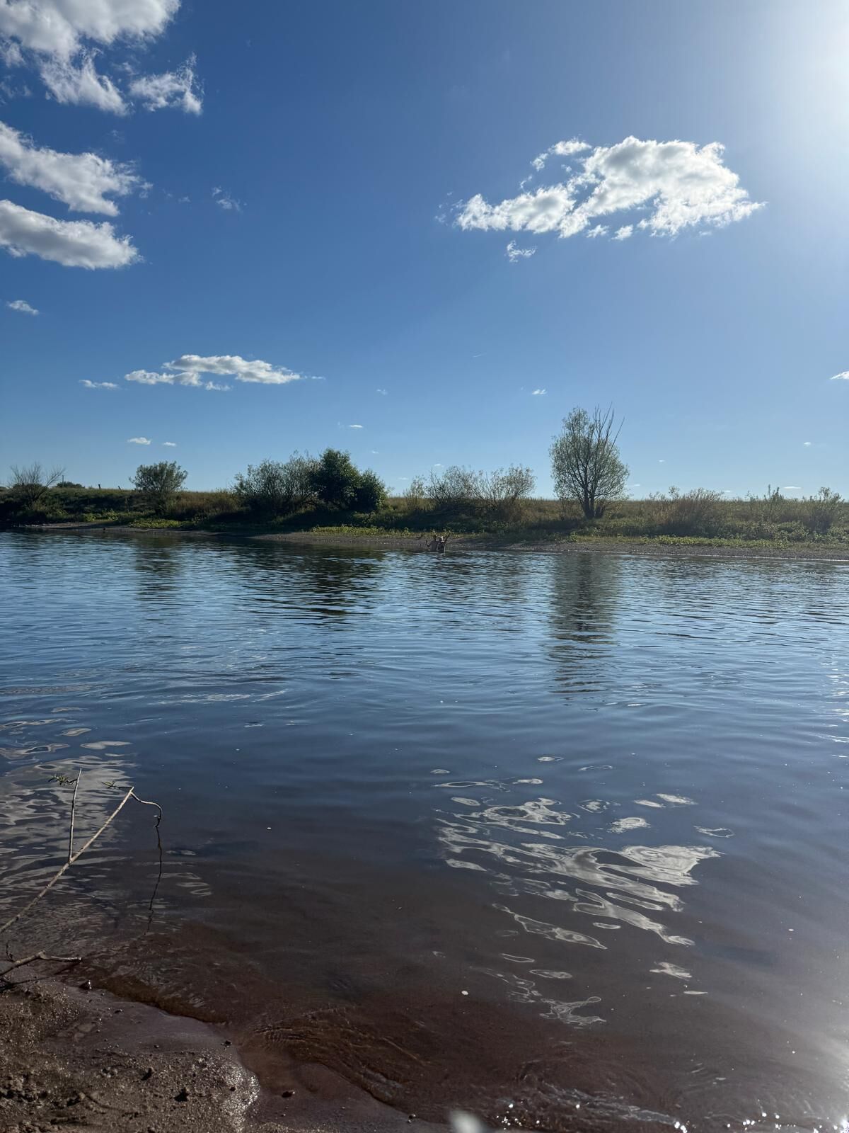 Un riu tranquil amb aigua cristal·lina que reflecteix el cel.