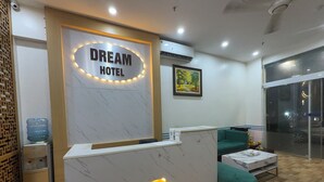 A reception desk with a marble top, a water dispenser, and a framed picture on the wall. - Dream Hotel (Hanoi)