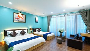 A hotel room with two beds, a desk, a sofa, and a large window with curtains. - Dream Hotel (Hanoi)