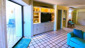 A living room with a television, cabinets, and a sofa.