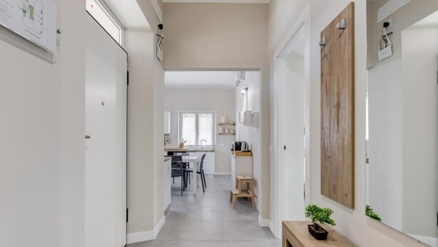 Un intérieur moderne avec un couloir menant à une salle à manger et à une cuisine.