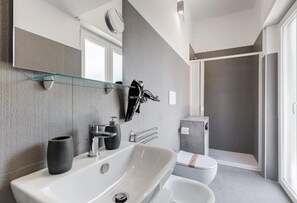 Une salle de bain moderne avec une grande baignoire, des toilettes et un espace douche.