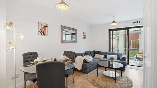 Un salon moderne avec un canapé, une table basse et un coin repas.