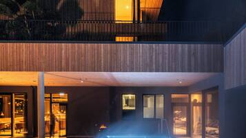 A modern hotel with a pool area, wooden exterior, and a visible sign reading "wollee".