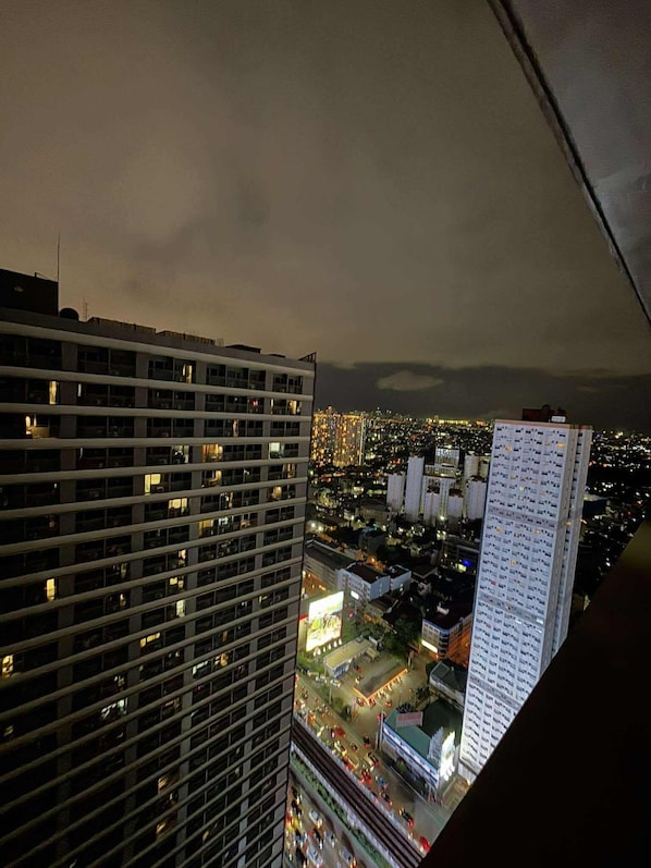 A high-rise building with multiple floors and a view of a cityscape at night.