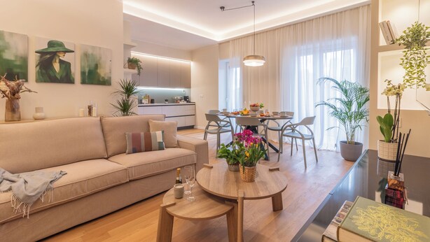 A modern living room with a sofa, coffee table, and dining area.