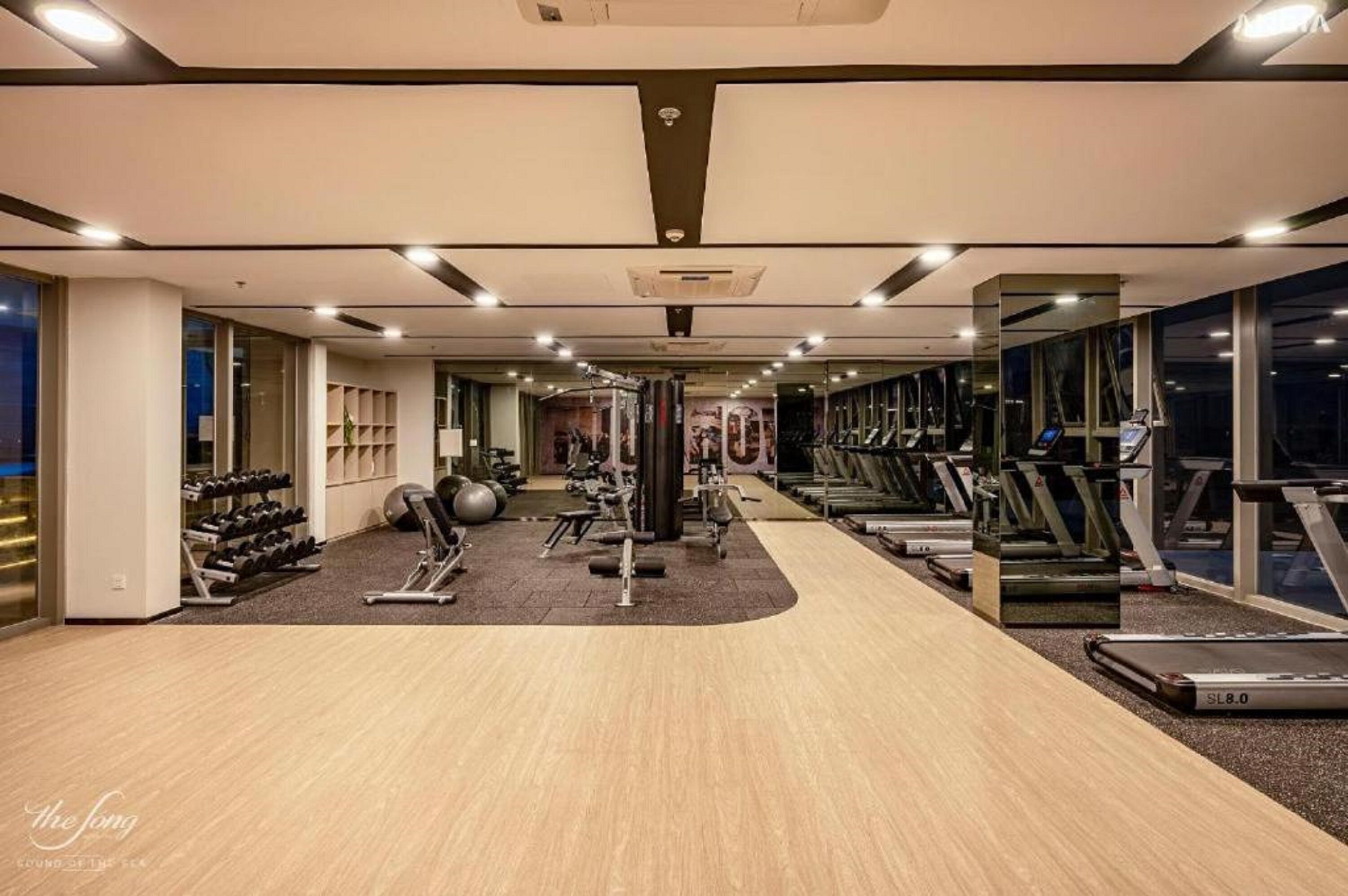 Une salle de sport moderne équipée de machines de cardio, de machines de musculation et de poids libres.