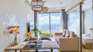 Una sala de estar moderna con comedor, ventanas amplias y vista a la ciudad.