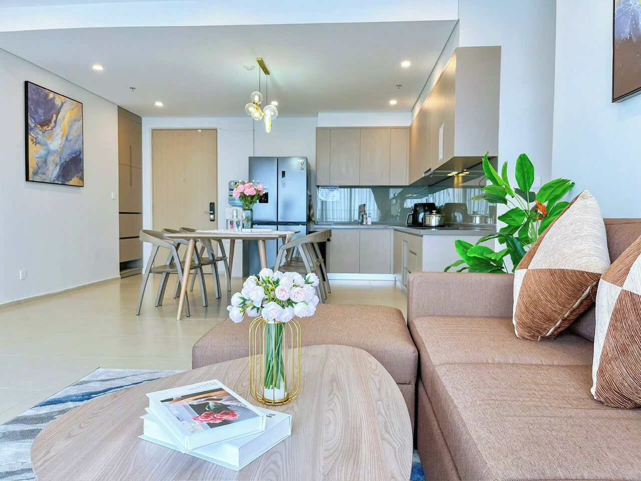Een moderne woonkamer met een bank, salontafel en een eethoek met stoelen.