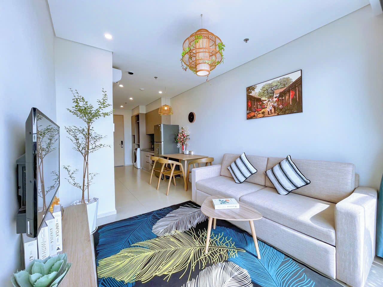 A modern living room with a sofa, coffee table, and a dining area with chairs.