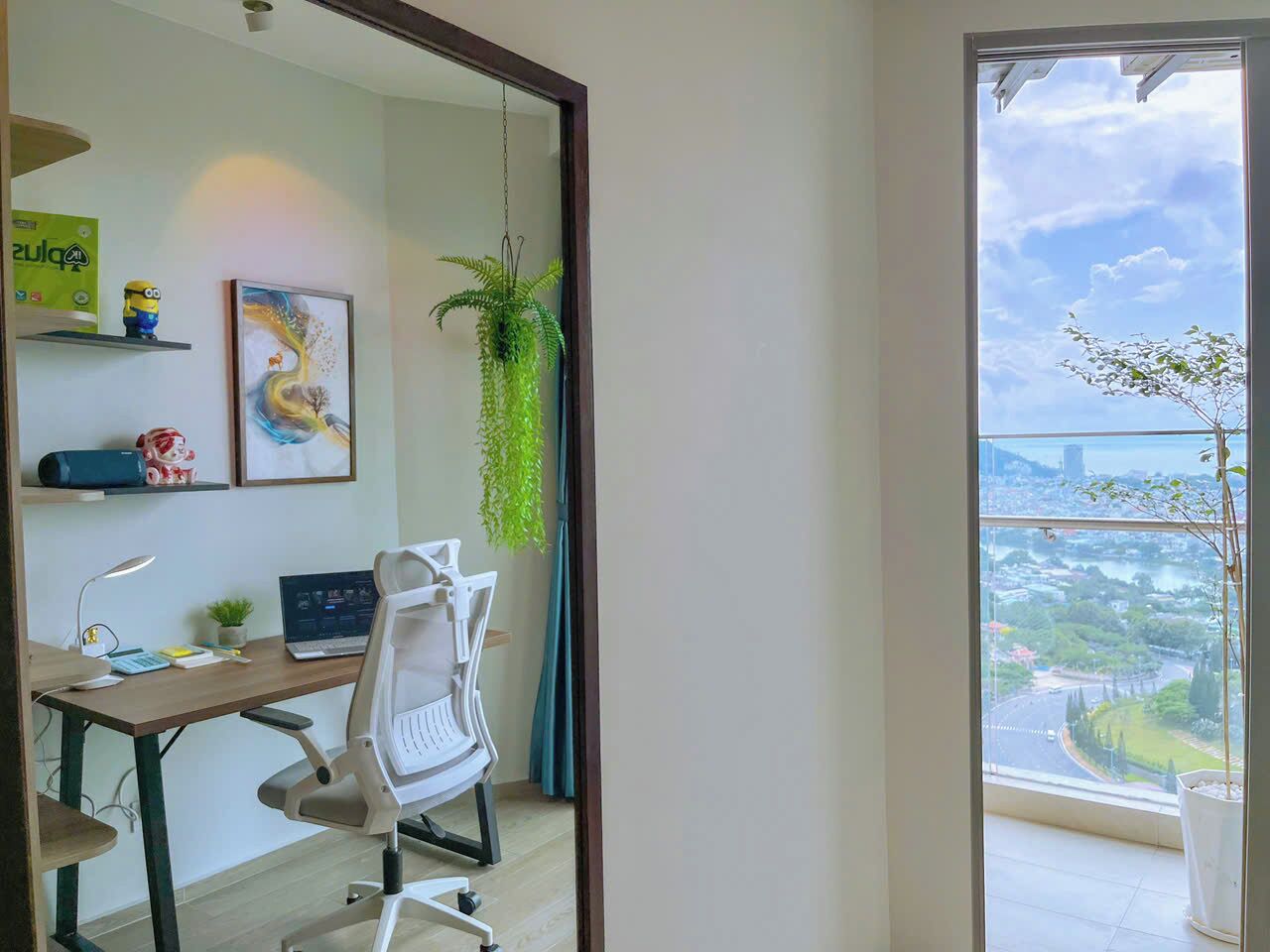A modern office space with a desk, chair, and a large window offering a city view.