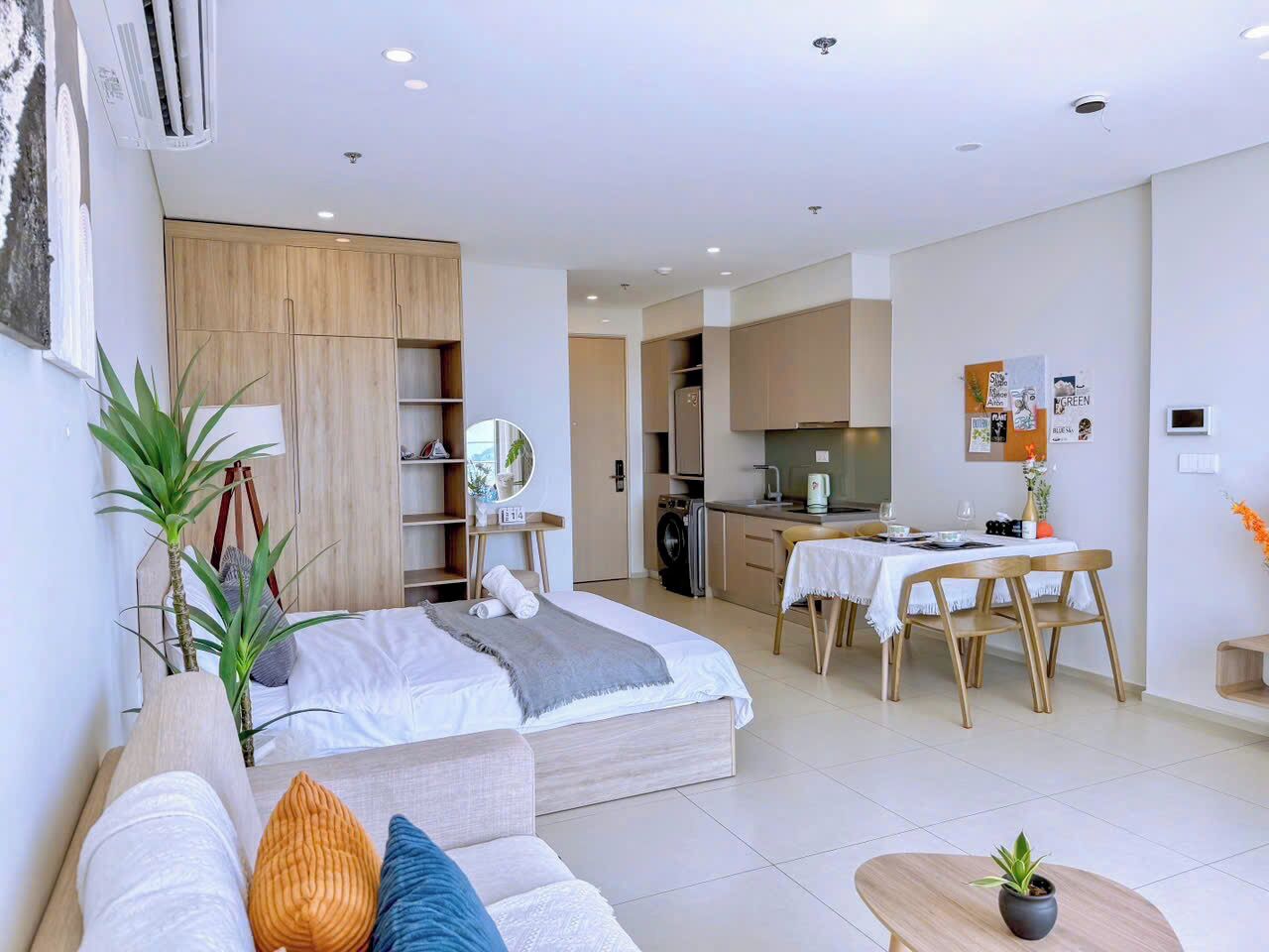 Un apartamento moderno con un dormitorio, kitchenette, comedor y sala de estar.