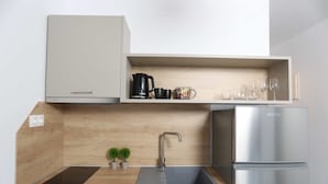 Una cocina moderna con un lavamanos empotrado, un refrigerador de acero inoxidable y una encimera de madera.