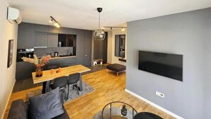 Een modern appartement met keuken, eethoek en woonkamer.
