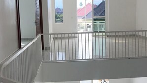 Een ruim, meerlaags interieur met een balkon, grote ramen en een modern design.