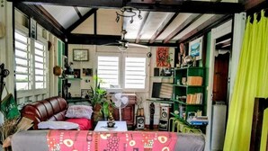 A cozy living room with a sofa, a fan, and a bookshelf. - Quiet, air-conditioned bed and breakfast 200 m from Le Diamant beach. (Le Diamant)