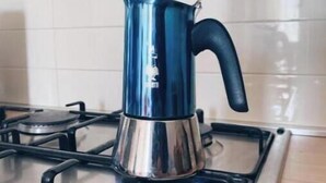 Estufa a gas de acero inoxidable con una tetera azul encima.