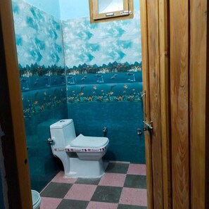 Un baño con inodoro, lavabo y zona de ducha.