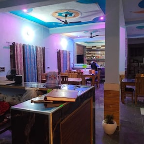 Amplia habitación con zona de bar, muebles de madera y ventilador de techo.