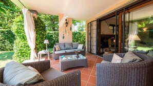 An outdoor patio with wicker furniture, a sofa, and a table. - Villa Federica by MMega (Forte dei Marmi)