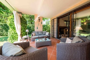 An outdoor patio with wicker furniture, a sofa, and a table.