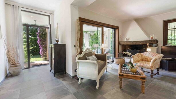 A spacious living room with a sofa, a coffee table, and a fireplace. - Villa Federica by MMega (Forte dei Marmi)