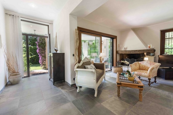 A spacious living room with a sofa, a coffee table, and a fireplace.