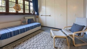 A room with a sofa, a chair, a patterned rug, a wardrobe, and a window with curtains. - Villa Federica by MMega (Forte dei Marmi)
