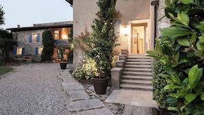 A building with a gravel driveway leading to a wooden staircase and a door.