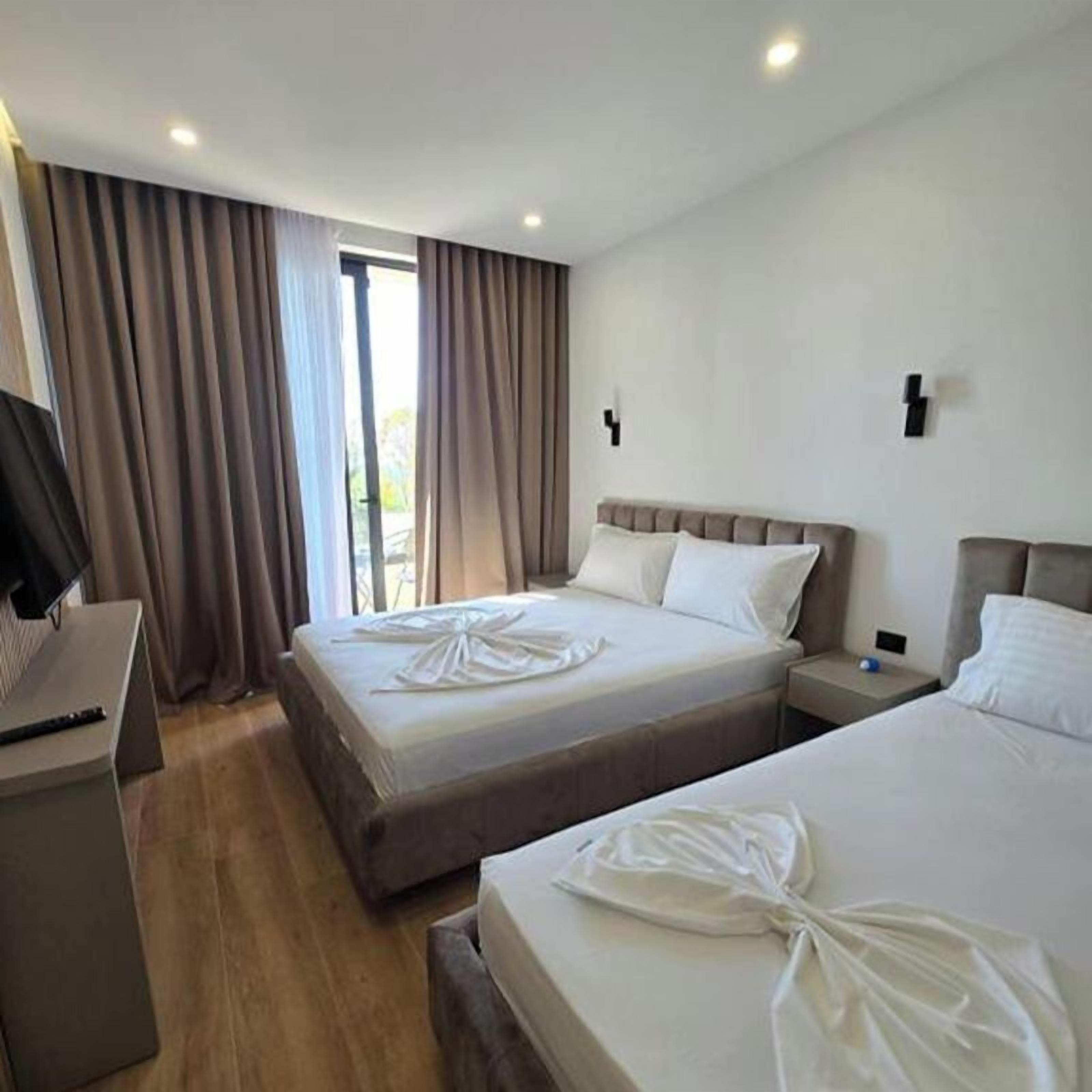 Een hotelkamer met twee bedden, een bureau en een televisie.